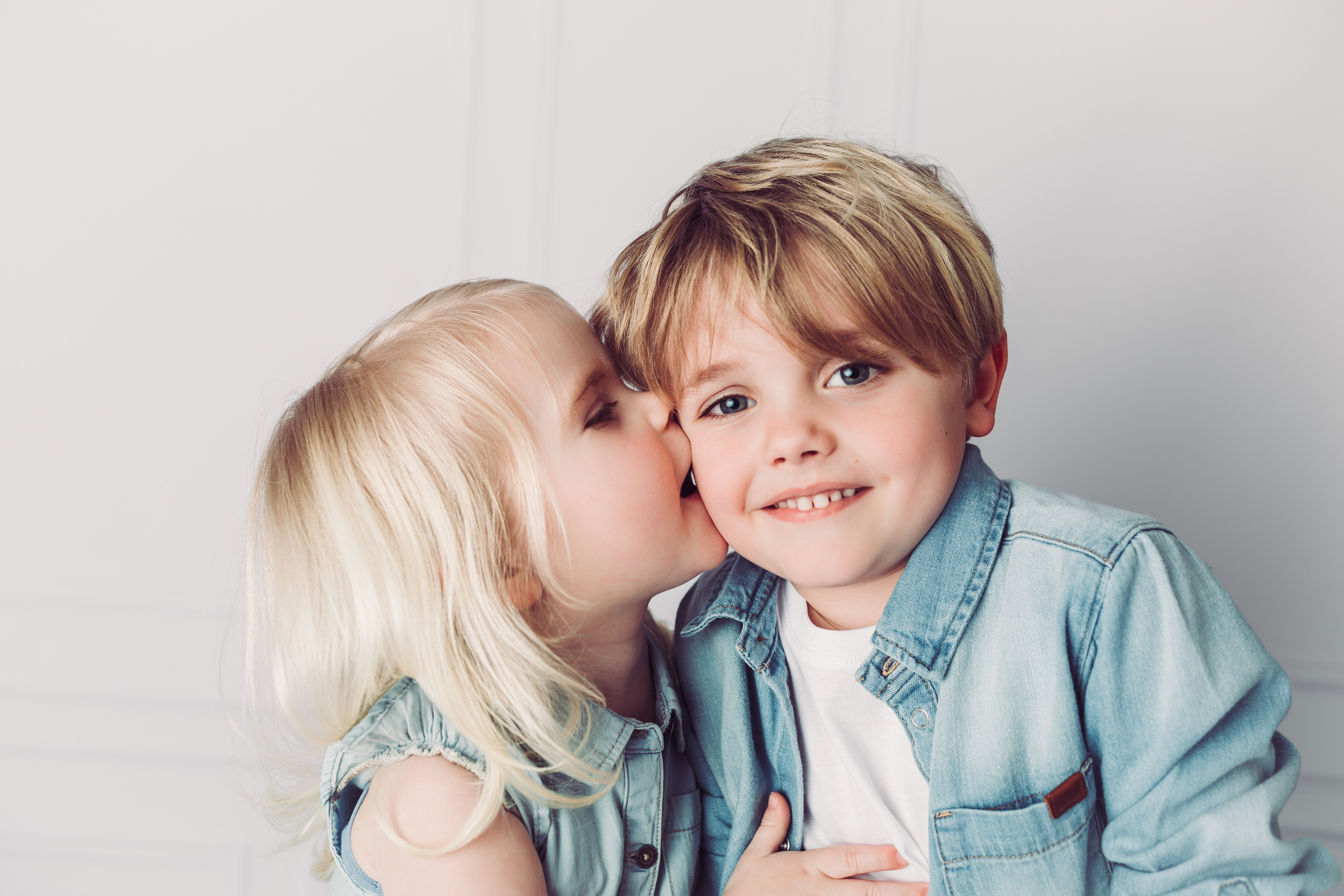 Junge und Mädchen posieren lächelnd für ein Foto.